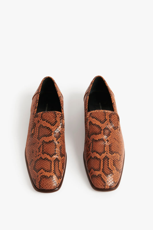 A pair of Victoria Beckham Hanna Loafer in Copper Snake Print with pointed toes, viewed from above, placed on a white background, perfect for Spring Summer 2022.