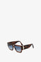 Rectangular V Plaque Frame Sunglasses In Dark Brown Horn with dark sculpted lenses and distinctive angular corner detailing from Victoria Beckham. Background is plain white.